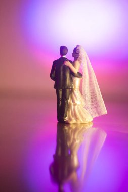 Düğün çifti pasta üstte plastik figürler smokin gece elbisesi, beyaz gelinlik peçesi.