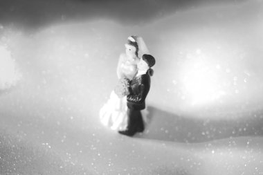 Düğün çifti pasta üstte plastik figürler smokin gece elbisesi, beyaz gelinlik peçesi.