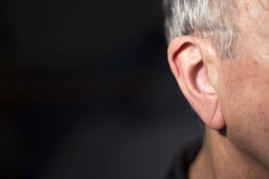 Modern dijital teknoloji işitme cihazı kulağına giyen sağır kıdemli vatandaş adam.