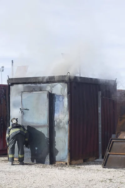 İtfaiyeci yangın söndürme istasyonunu söndürüyor. Acil durum güvenlik tatbikatı prosedürü..