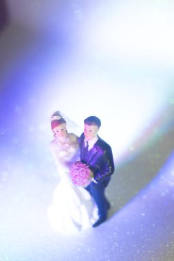 Düğün çifti pasta üstte plastik figürler smokin gece elbisesi, beyaz gelinlik peçesi.