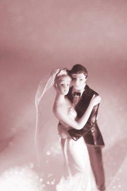 Düğün çifti pasta üstte plastik figürler smokin gece elbisesi, beyaz gelinlik peçesi.