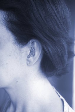 Sağır orta yaşlı Bayan modern dijital teknoloji işitme cihazı kulağına giyiyor.