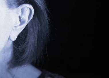 Kulağına modern dijital yüksek teknolojili işitme cihazı takan sağır yaşlı kadın..