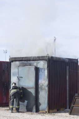 İtfaiyeci yangın söndürme istasyonunu söndürüyor. Acil durum güvenlik tatbikatı prosedürü..