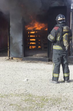 İtfaiyeci yangın söndürme istasyonunu söndürüyor. Acil durum güvenlik tatbikatı prosedürü..