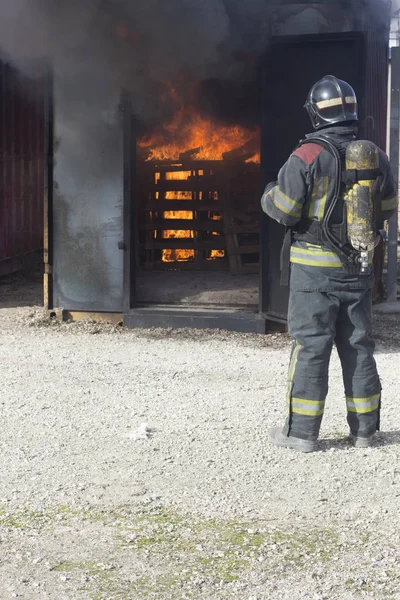 Firefighter putting out fire training station extinguisher backdraft emergency safety drill procedure.