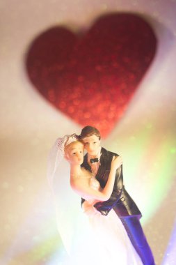 Düğün çifti pasta üstte plastik figürler smokin gece elbisesi, beyaz gelinlik peçesi.