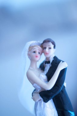 Düğün çifti pasta üstte plastik figürler smokin gece elbisesi, beyaz gelinlik peçesi.