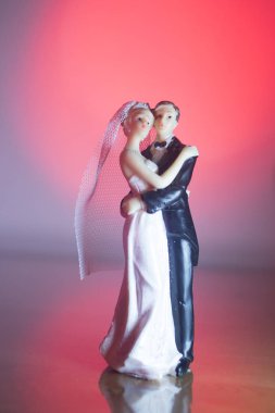 Düğün çifti pasta üstte plastik figürler smokin gece elbisesi, beyaz gelinlik peçesi.