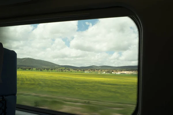 View from high speed train window in motion of countrysideand sky on sunny warm Spring day in Spain