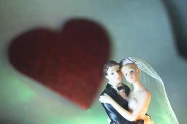 Düğün çifti pasta üstte plastik figürler smokin gece elbisesi, beyaz gelinlik peçesi.