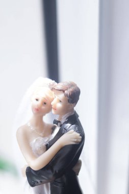 Düğün çifti pasta üstte plastik figürler smokin gece elbisesi, beyaz gelinlik peçesi.