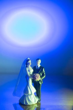 Düğün çifti pasta üstte plastik figürler smokin gece elbisesi, beyaz gelinlik peçesi.