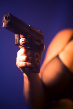 Seksi, iri göğüslü, otomatik tabancalı, erotik iç çamaşırlı kadın..