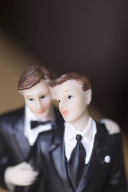 Cake topper gay wedding couple of two male grooms holding romantic marriage embrace of LGBT love. clipart