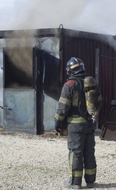 İtfaiyeci yangın söndürme istasyonunu söndürüyor. Acil durum güvenlik tatbikatı prosedürü..