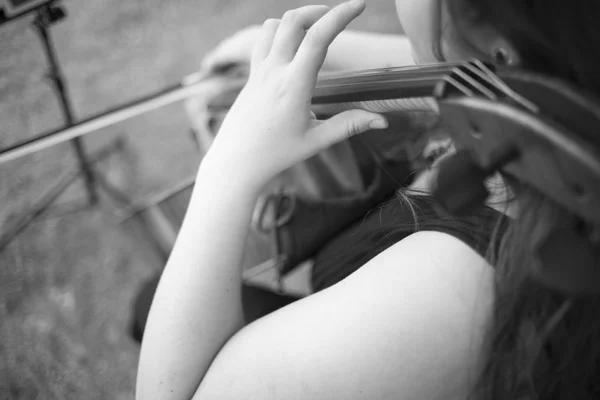 Musicians group playing wedding music during outdoors marriage reception in luxury hotel garden.