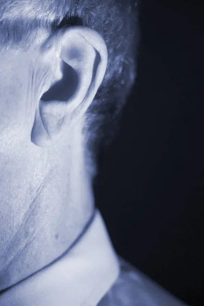 聴覚障害者高齢者男の耳で身に着けている現代デジタル高技術補聴器 — ストック写真