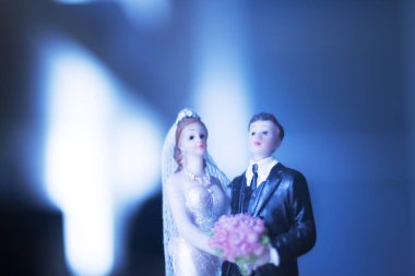 Düğün çifti pasta üstte plastik figürler smokin gece elbisesi, beyaz gelinlik peçesi.