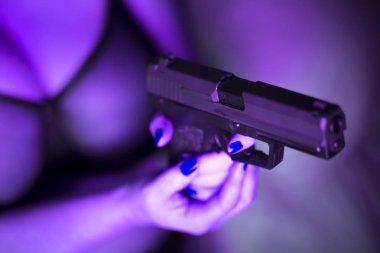 Seksi, iri göğüslü, otomatik tabancalı, erotik iç çamaşırlı kadın..