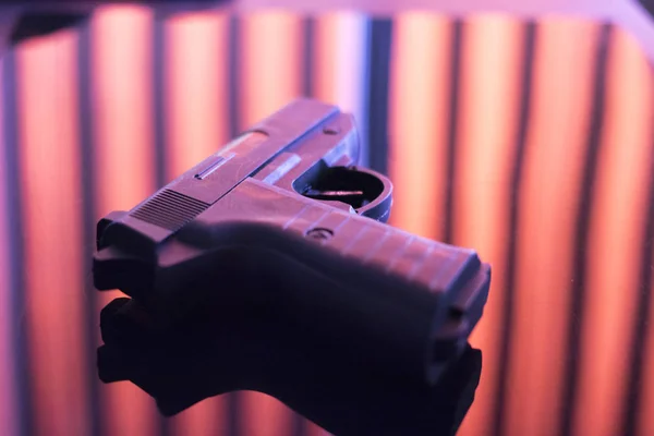 Automatic pistol handgun in artistic light effect moody atmospheric photo creative artistic closeup