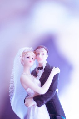 Düğün çifti pasta üstte plastik figürler smokin gece elbisesi, beyaz gelinlik peçesi.