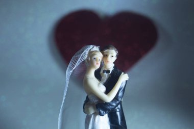 Düğün çifti pasta üstte plastik figürler smokin gece elbisesi, beyaz gelinlik peçesi.