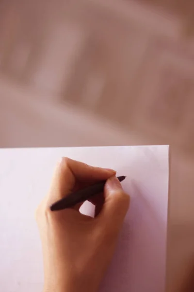 Νεαρή Κυρία Που Γράφει Χαρτί Μολύβι Στο Χέρι Στο Τραπέζι — Φωτογραφία Αρχείου