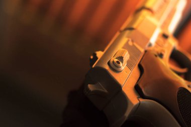 Otel yatak odasında atmosferik karanlık dramatik fotoğraf tabloda otomatik tabanca silah tabanca.