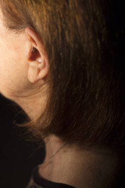 Kulağına modern dijital yüksek teknolojili işitme cihazı takan sağır yaşlı kadın..