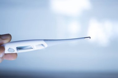 Doktor veya hemşire ile hasta sıcaklığını ölçmek için kullanılan dijital termometre tıbbi alet