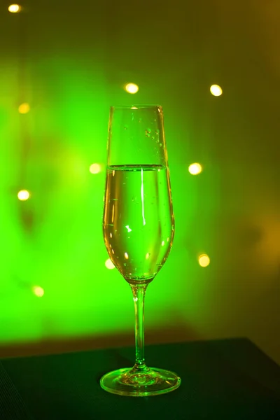 Champagne sparkling wine glass of prosecco cava in discotque party bar during wedding in Ibiza Spain with lights behind.