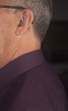 Modern dijital teknoloji işitme cihazı kulağına giyen sağır kıdemli vatandaş adam.