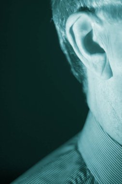 Modern dijital teknoloji işitme cihazı kulağına giyen sağır kıdemli vatandaş adam.