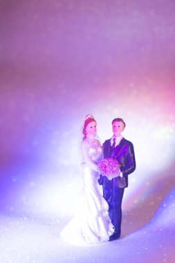 Düğün çifti pasta üstte plastik figürler smokin gece elbisesi, beyaz gelinlik peçesi.