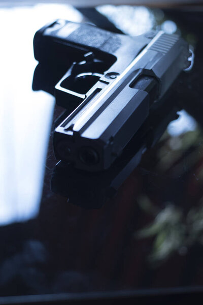 Automatic pistol handgun in artistic light effect moody atmospheric photo creative artistic closeup