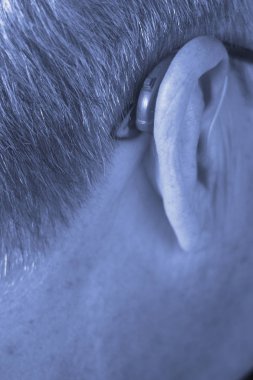 Modern dijital teknoloji işitme cihazı kulağına giyen sağır kıdemli vatandaş adam.