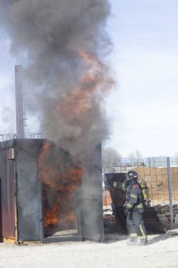 İtfaiyeci yangın söndürme istasyonunu söndürüyor. Acil durum güvenlik tatbikatı prosedürü..