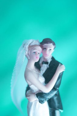 Düğün çifti pasta üstte plastik figürler smokin gece elbisesi, beyaz gelinlik peçesi.