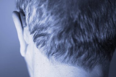 Modern dijital teknoloji işitme cihazı kulağına giyen sağır kıdemli vatandaş adam.