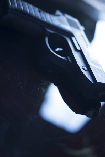 Automatic pistol handgun in artistic light effect moody atmospheric photo creative artistic closeup