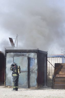 İtfaiyeci yangın söndürme istasyonunu söndürüyor. Acil durum güvenlik tatbikatı prosedürü..