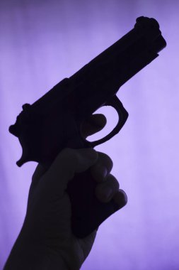 Öldürücü atmosferik karanlık dramatik fotoğrafın siluetinde otomatik tabanca..
