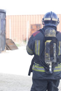 İtfaiyeci yangın söndürme istasyonunu söndürüyor. Acil durum güvenlik tatbikatı prosedürü..