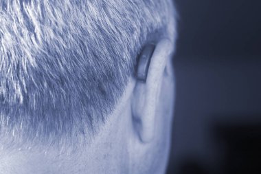 Modern dijital teknoloji işitme cihazı kulağına giyen sağır kıdemli vatandaş adam.