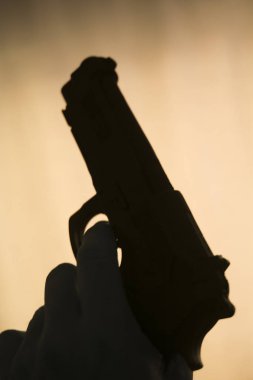 Öldürücü atmosferik karanlık dramatik fotoğrafın siluetinde otomatik tabanca..