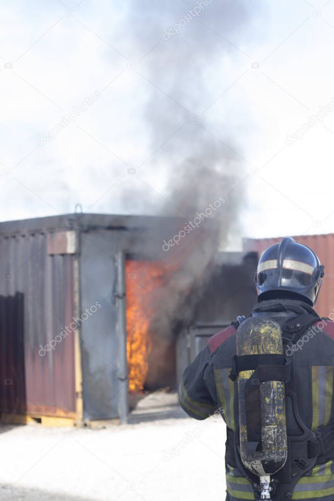 Firefighter putting out fire training station extinguisher backdraft emergency safety drill procedure.