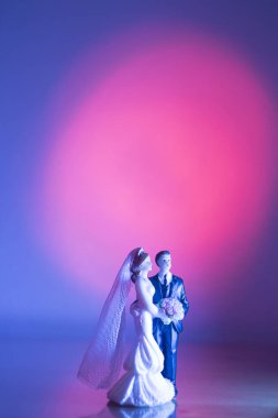 Düğün çifti pasta üstte plastik figürler smokin gece elbisesi, beyaz gelinlik peçesi.