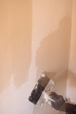 Bina yenileme çalışmaları, duvarları yenilemek için inşaat işçilerinin yaptığı yenilemeleri gösteriyor..